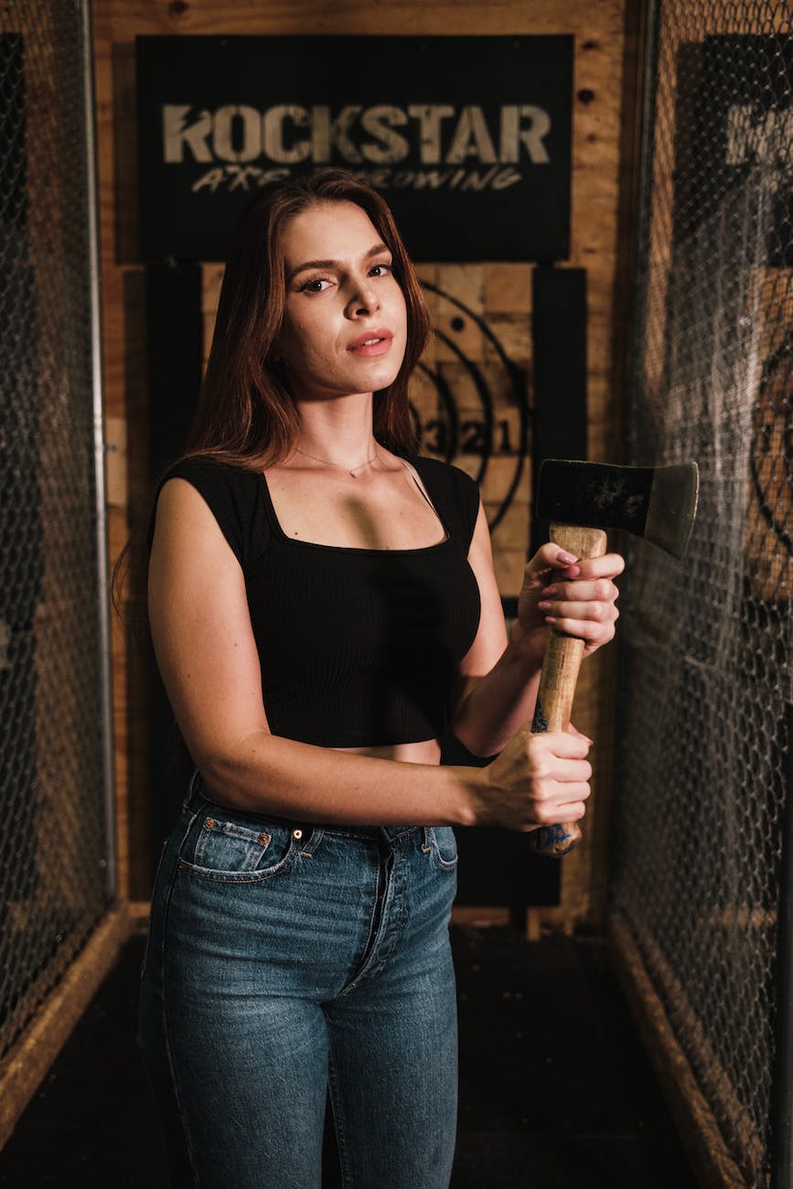 woman in black tank top holding an axe