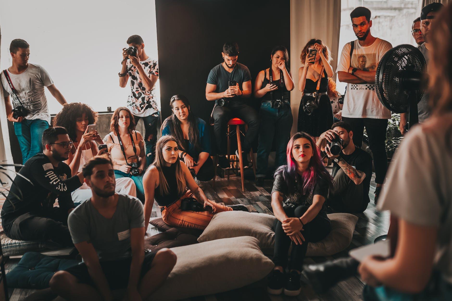 young diverse people gathering in studio and listening to speaker