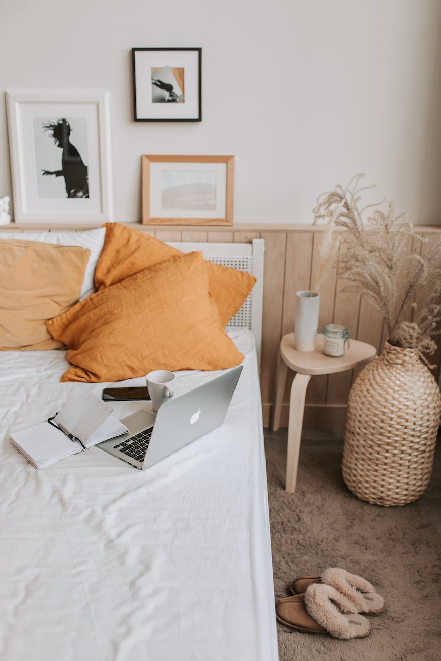 empty bed with laptop and notebook