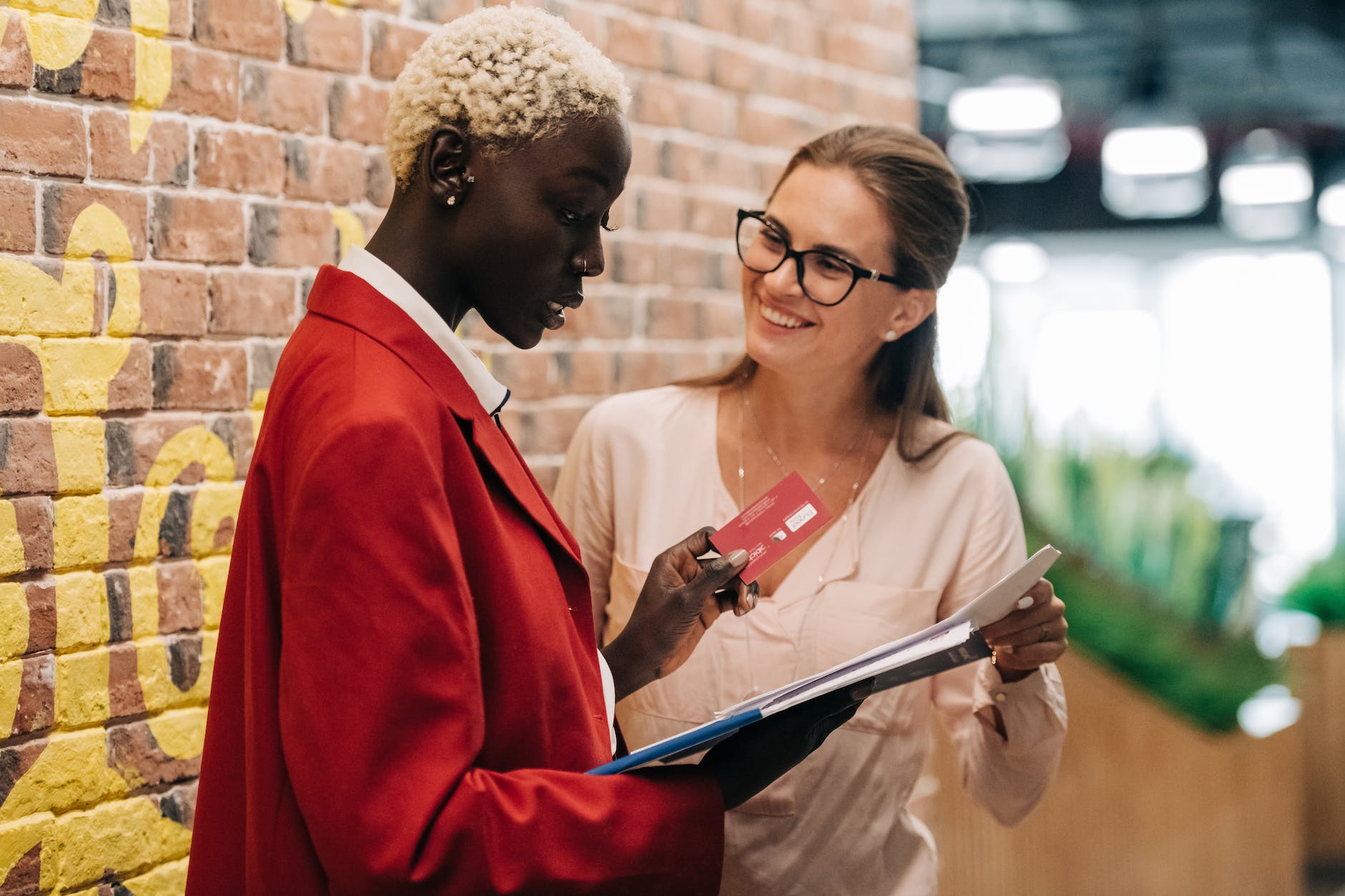 multiethnic businesswomen discussing payment with credit card