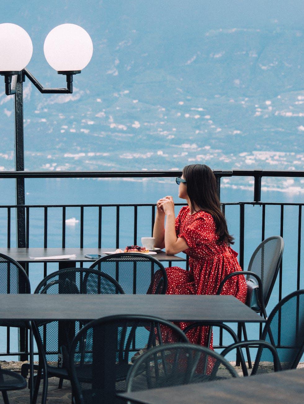 woman sitting in cafe at terrace near sea