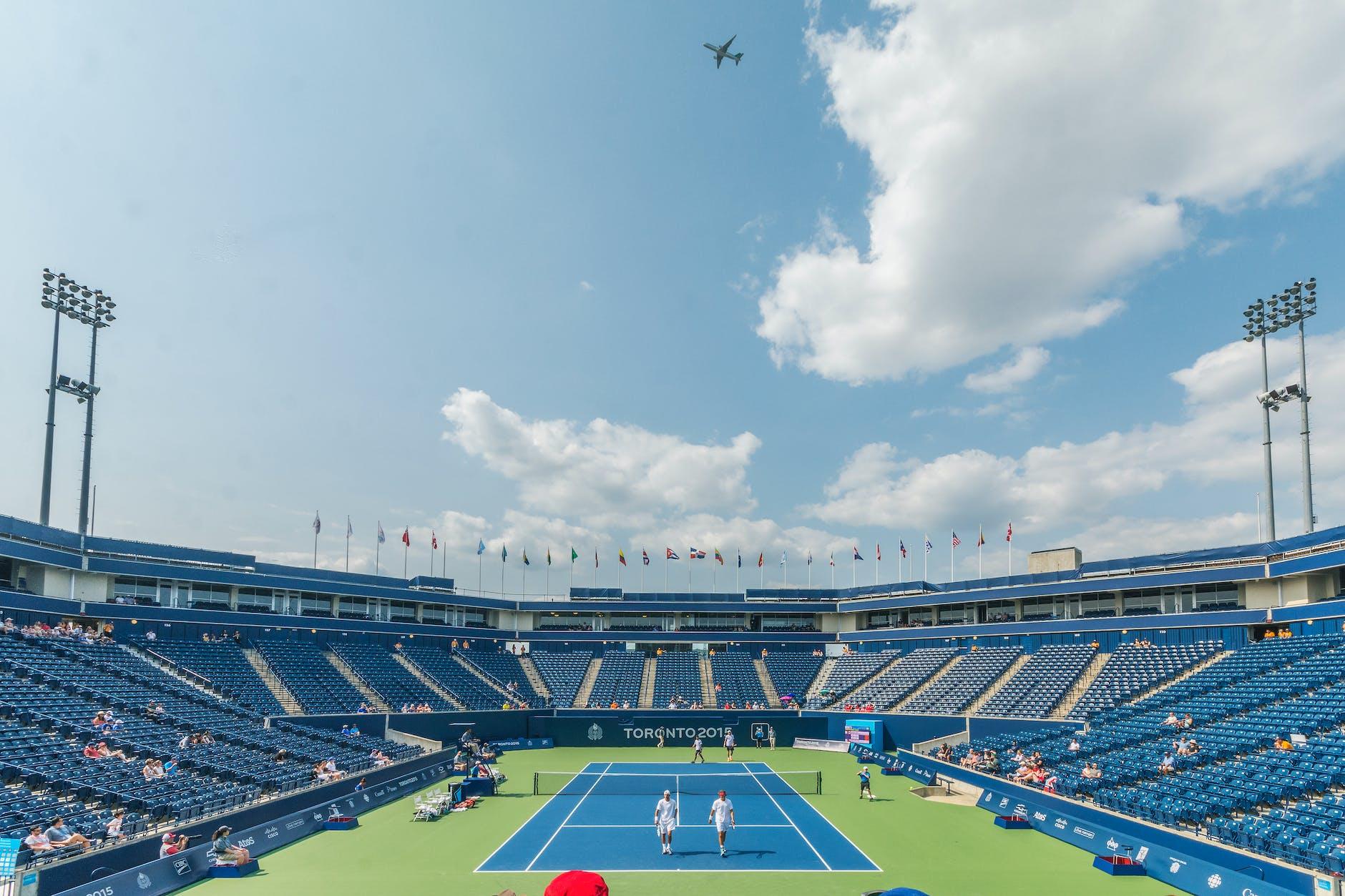 people standing on blue and green tennis court