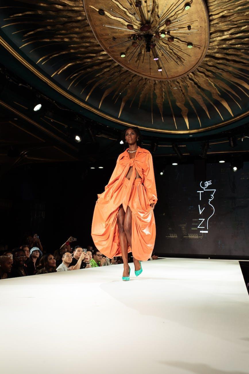 woman in orange robe standing on stage