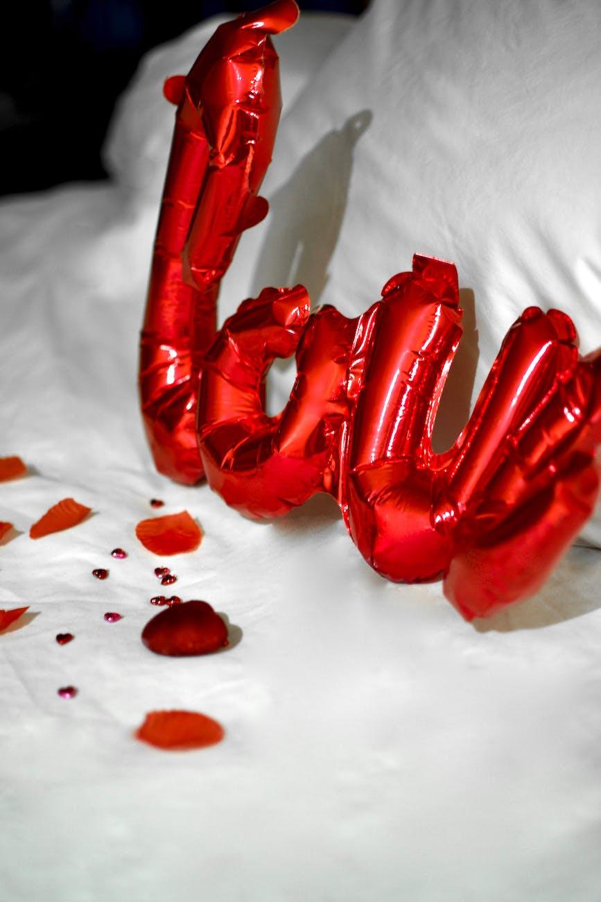 red plastic balloon on white textile