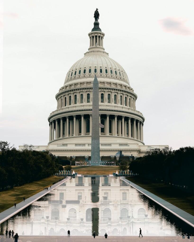 washington state capitol facade reflecting in pond under white sky