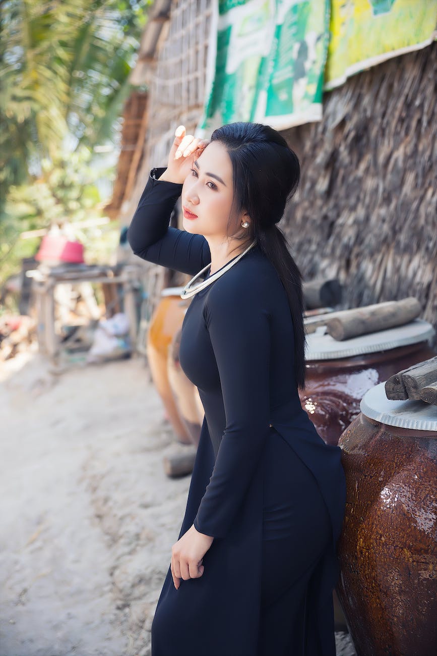 woman in black apparel standing near big brown clay pot