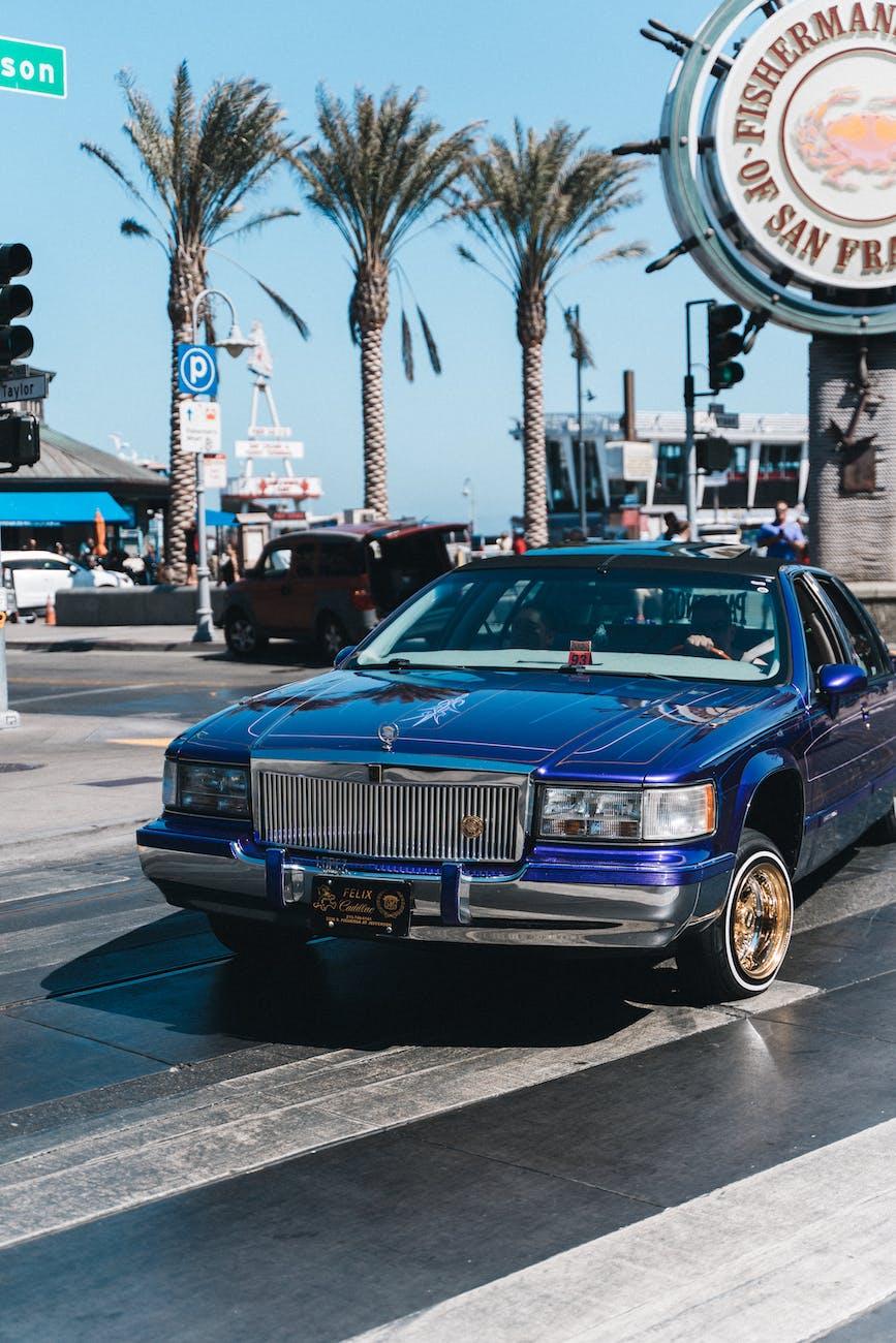 blue car parked on the concrete pavement