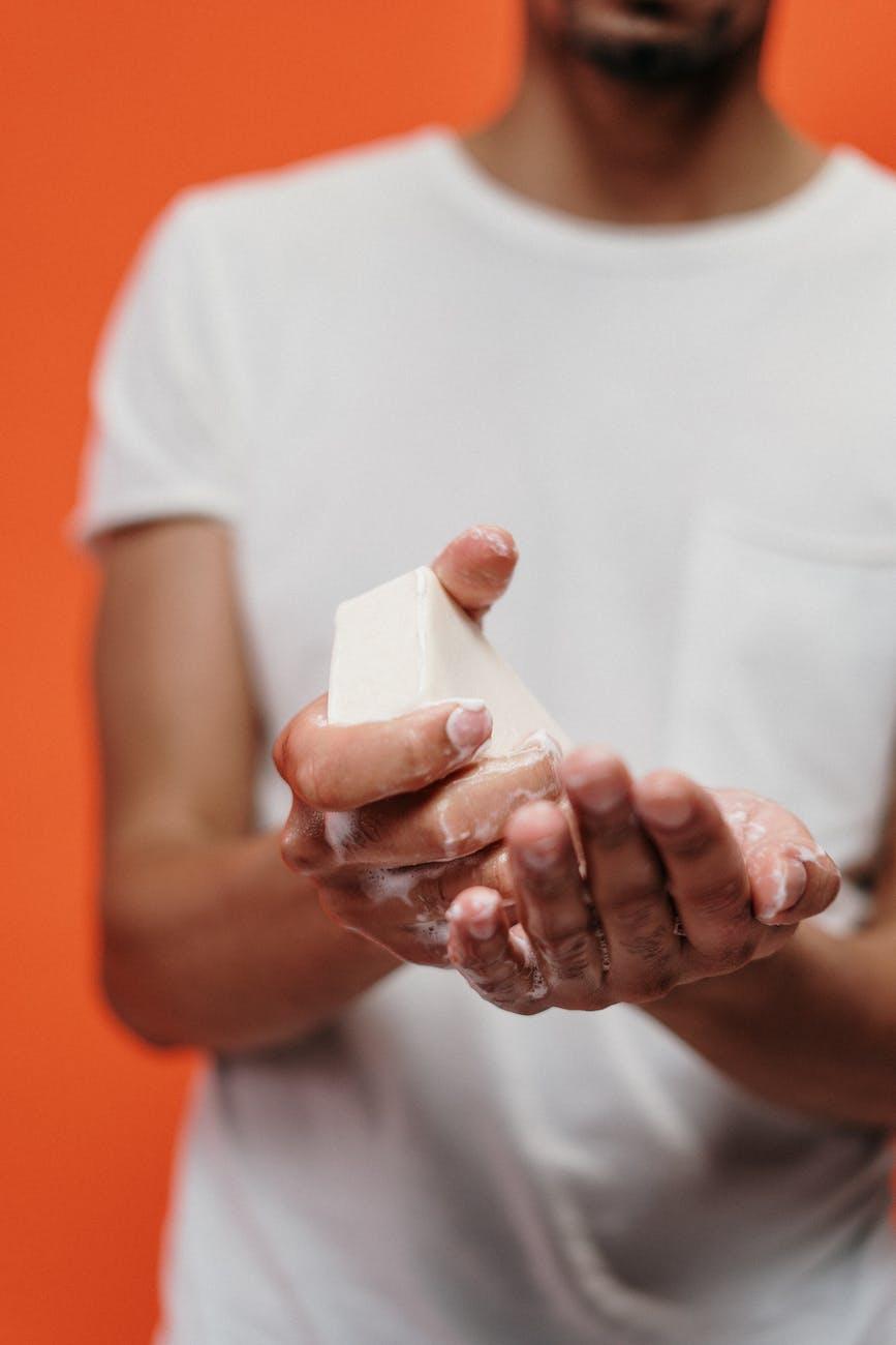 person in white crew neck t shirt holding bar soap