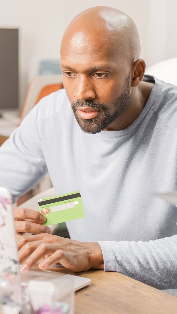 a bearded man holding a bank card