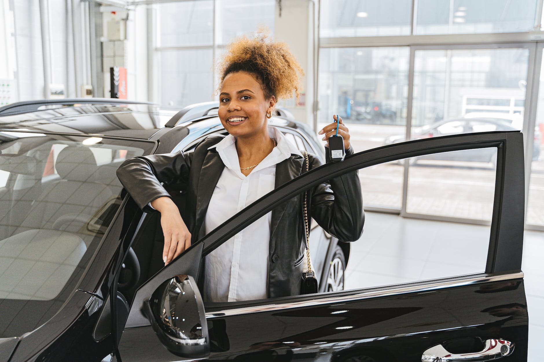 woman in black blazer standing beside black car