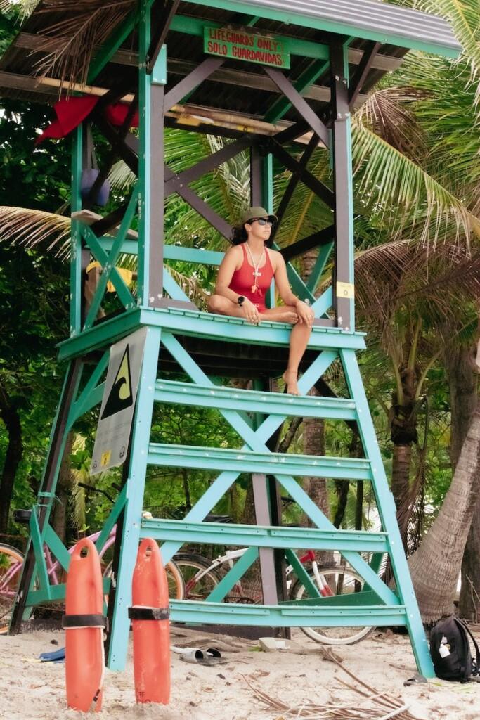 woman sitting on lifeguard tower