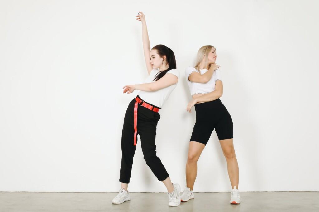 cool females dancing on white background