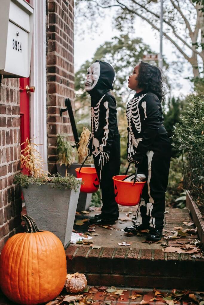 kids wearing halloween costumes doing trick or treat