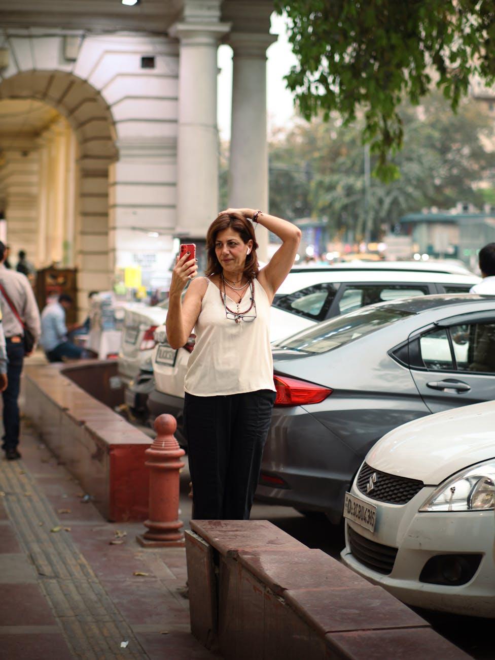 woman talking on smartphone near parking lot on street