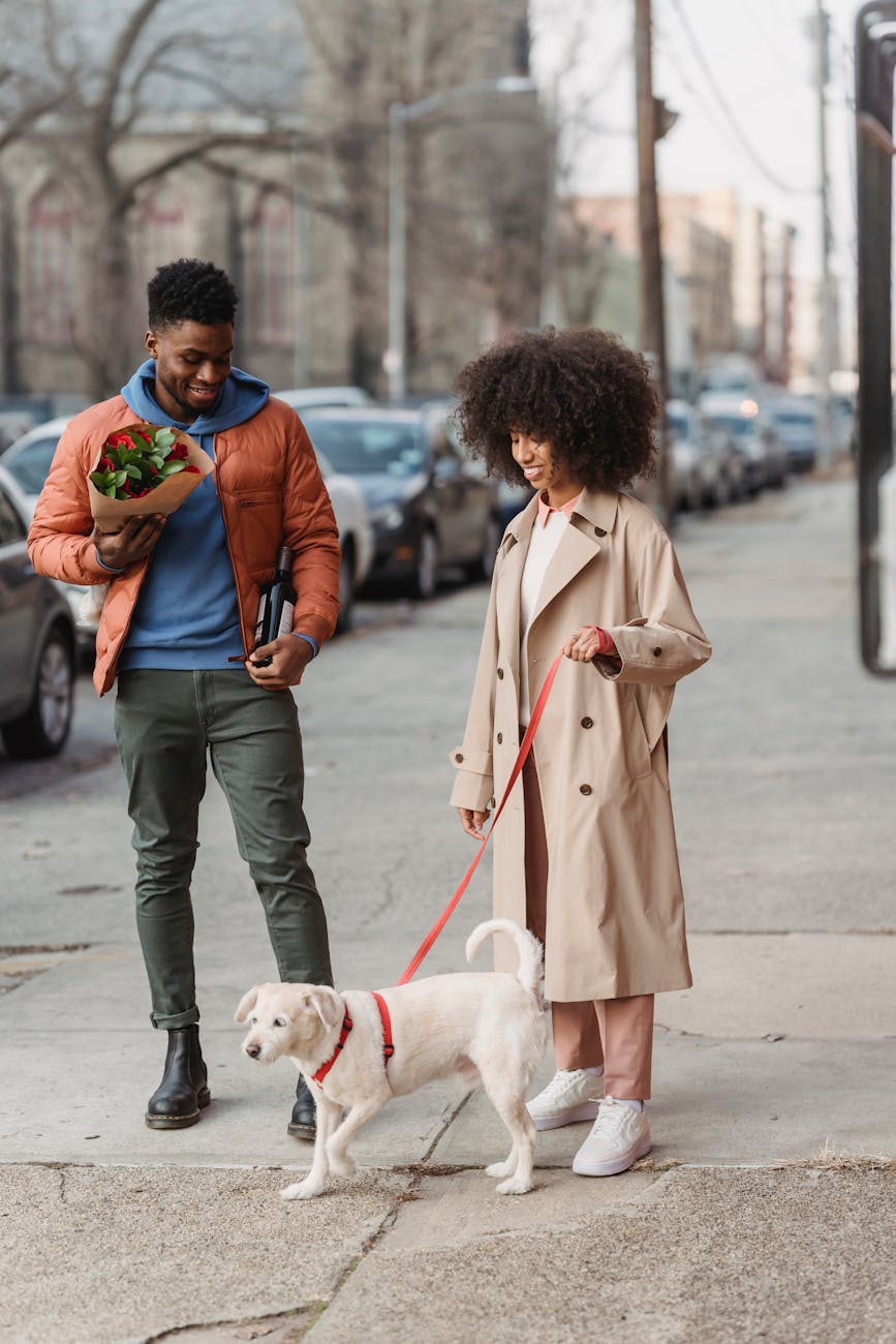 black happy couple walking with dog on street