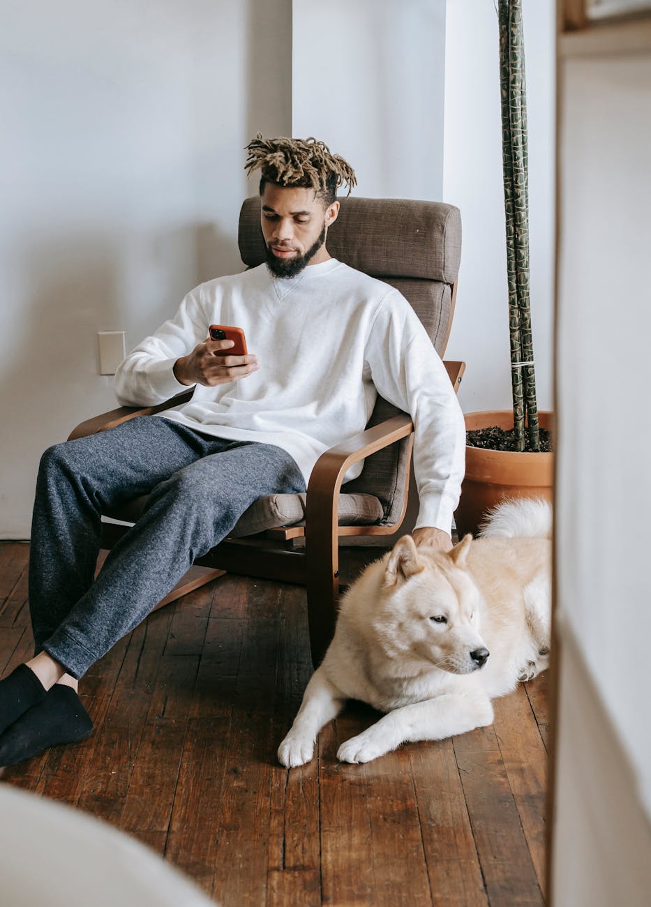 man sitting beside a dog