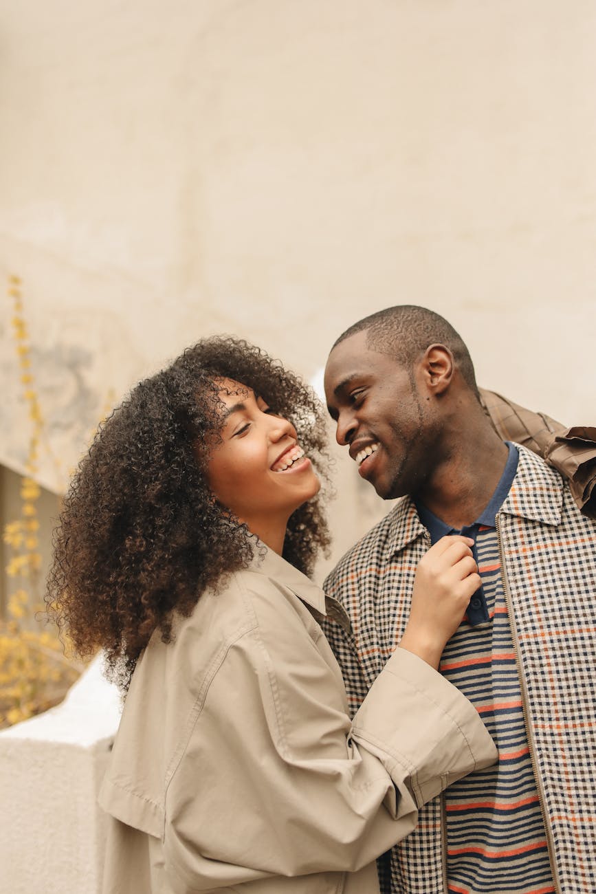 man in plaid jacket beside woman in brown coat