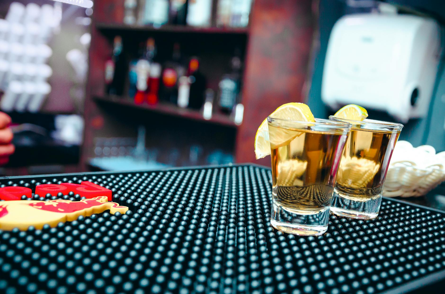 two clear shot glasses filled with alcohol