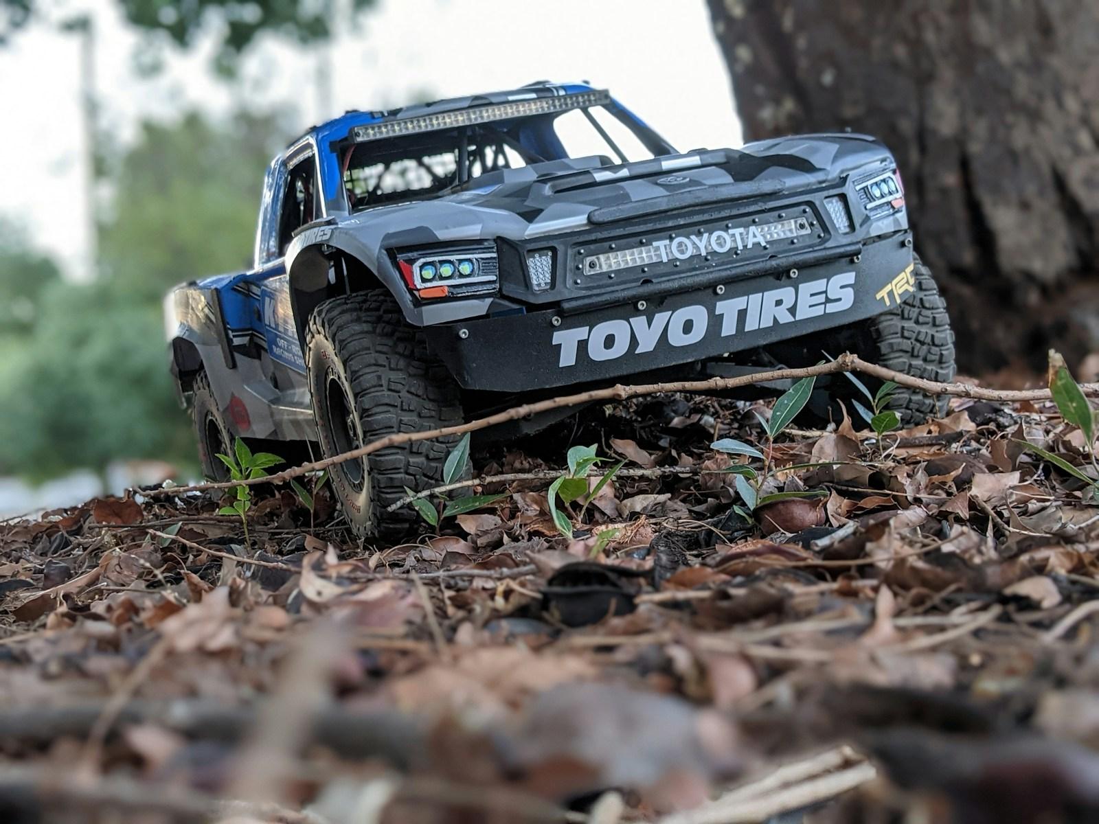 a toy truck is parked next to a tree