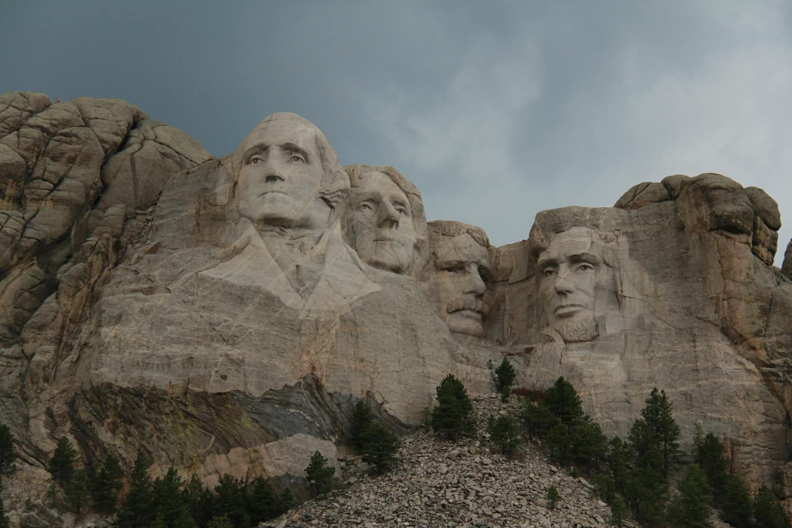 Iconic Mount Rushmore with presidential sculptures against a cloudy sky.