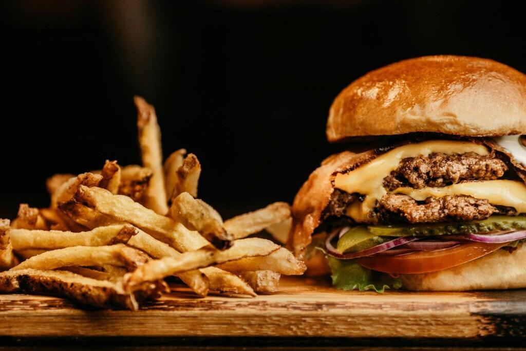 Mouthwatering cheeseburger and crispy fries on a wooden board, perfectly capturing fast food appeal.