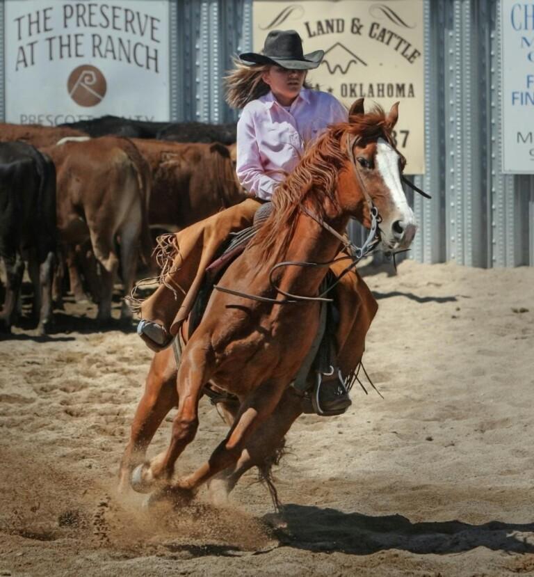 Cowgirl skillfully rides horse in a thrilling rodeo event, capturing Western lifestyle.