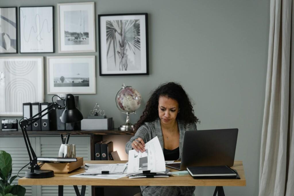 Focused professional adult reviewing documents at desk in a modern office setting.