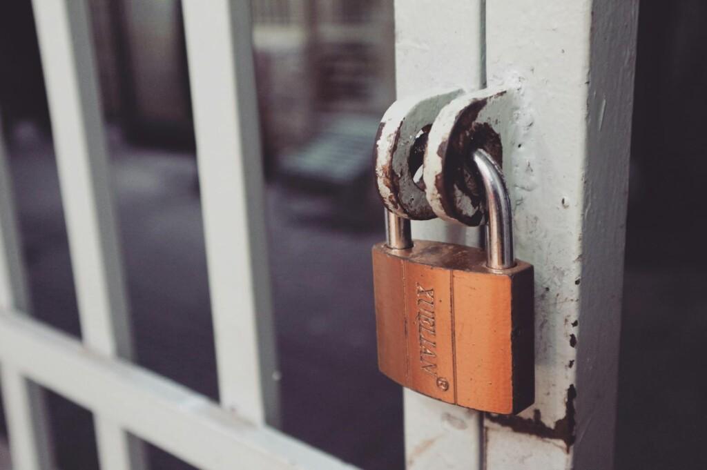 Closeup of a rusty padlock on a metal gate providing security and protection.