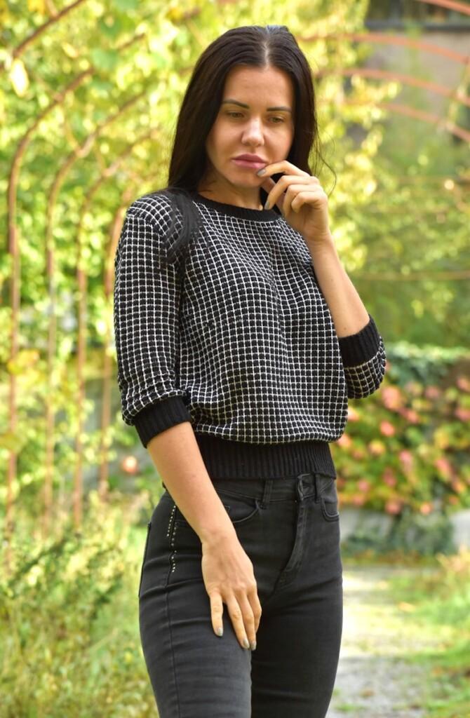 A woman in black and white shirt standing on a path