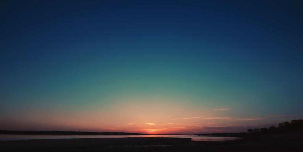 body of water under blue sky during sunset