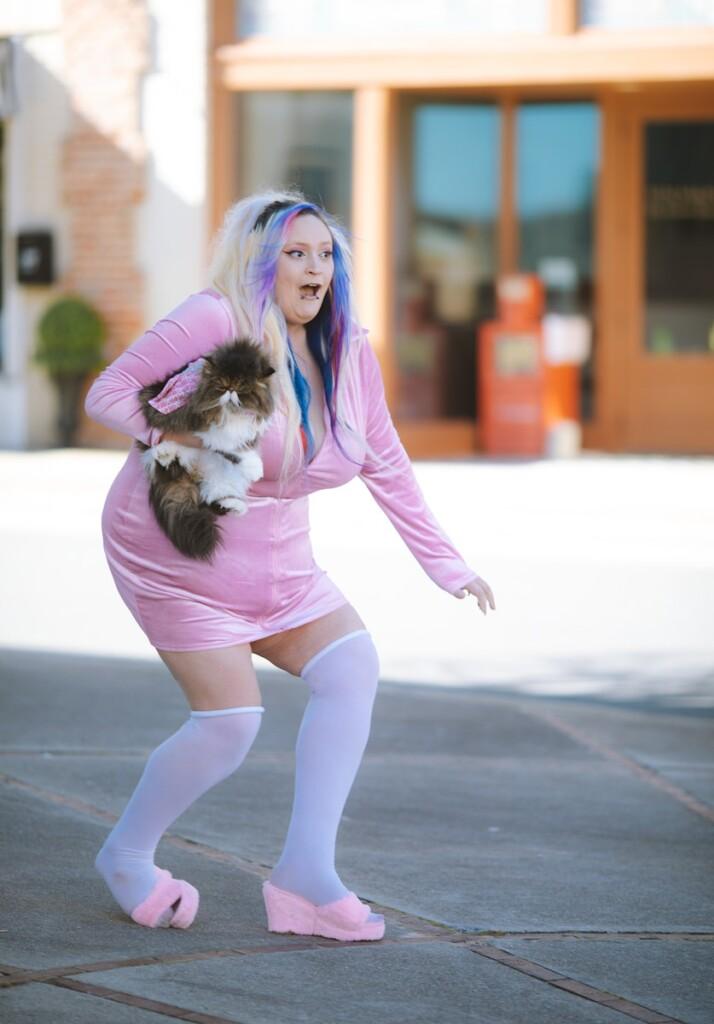 a woman in a pink dress holding a dog