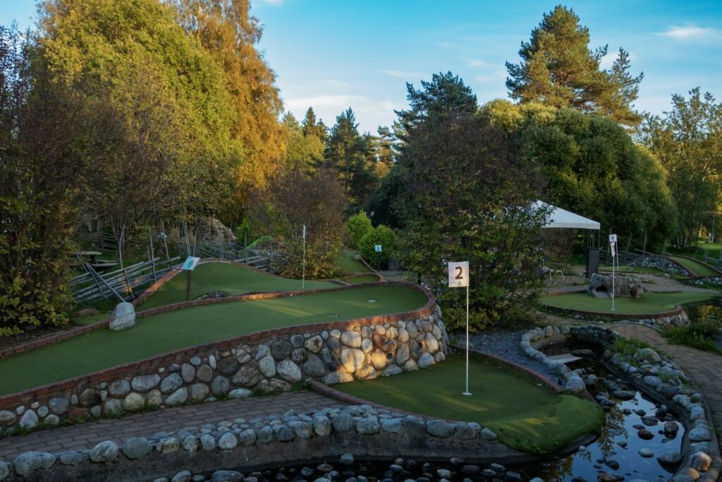 A golf course surrounded by trees and water